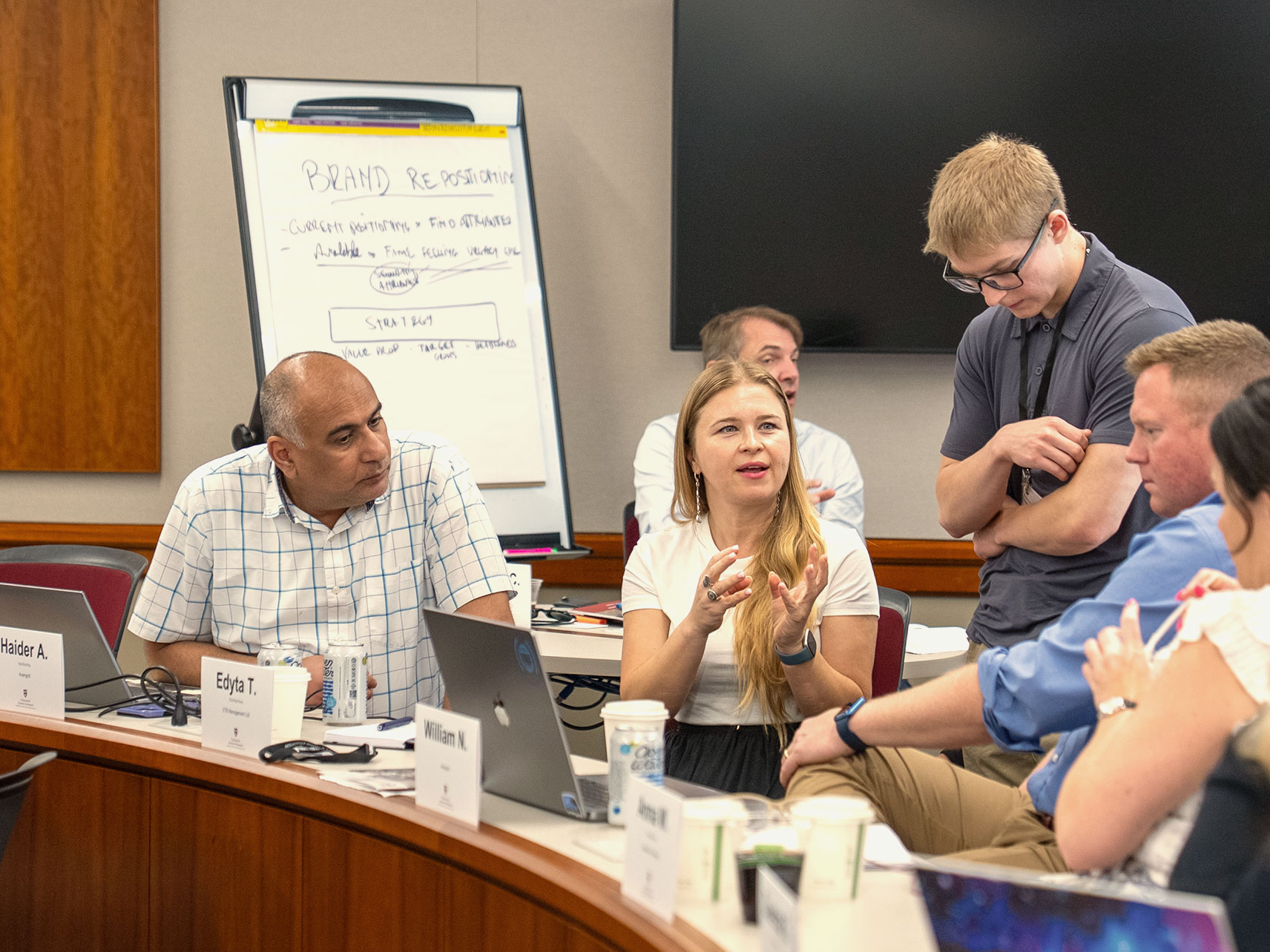 A group of professional development program participants talk in class.