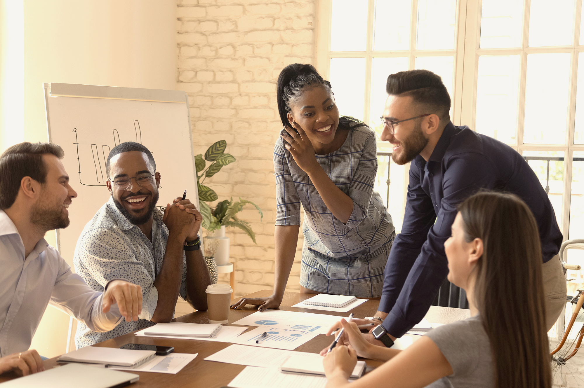 A group of employees engaged in conversation in a positive workplace environment.