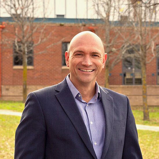 PDP Participant James Fletcher stands in front of a brick building