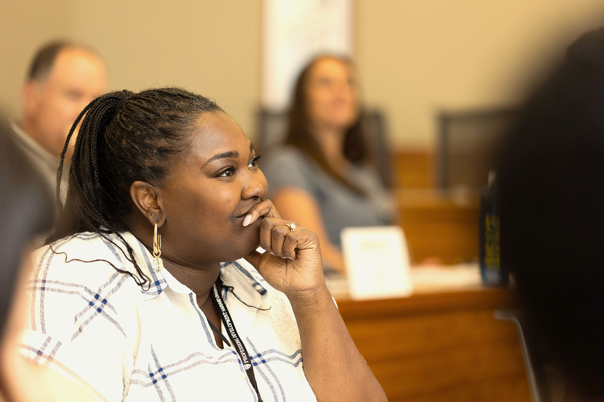 A woman listens attentively in a professional development classroom.
